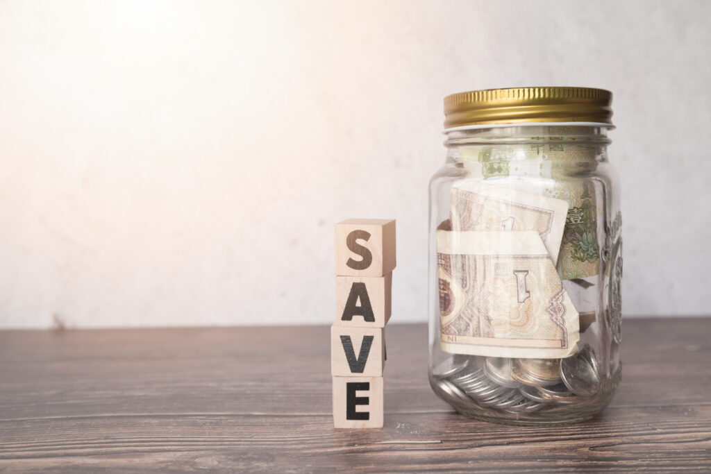 glass jar savings with wooden word scaled