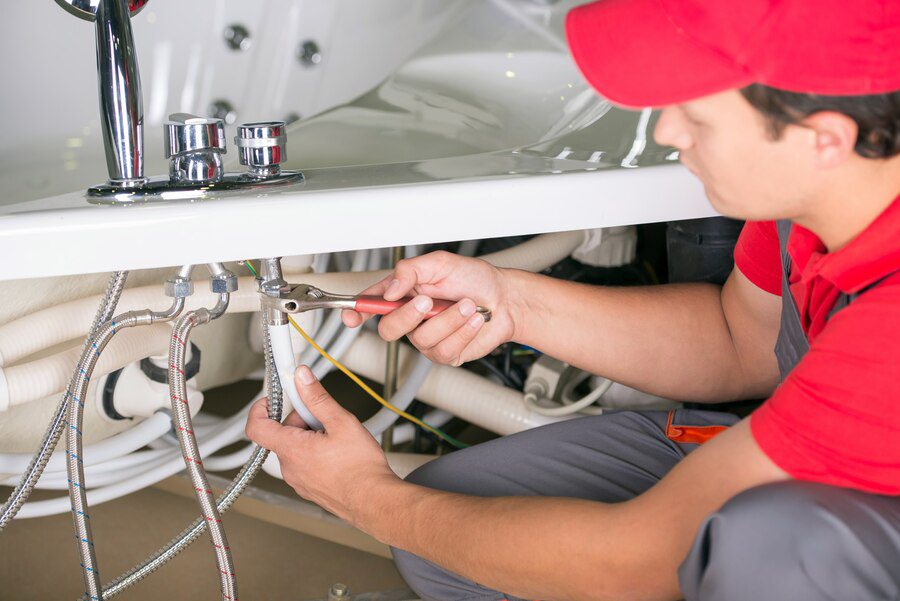 male plumber fixing sink pipe bathroom